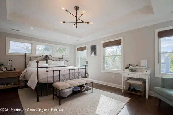 a bedroom with a bed couch and windows