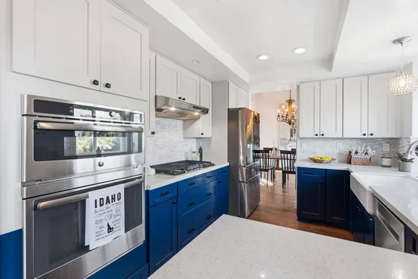 a kitchen with stainless steel appliances granite countertop a stove a refrigerator and a microwave