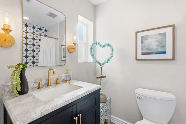 a bathroom with a granite countertop sink and a mirror