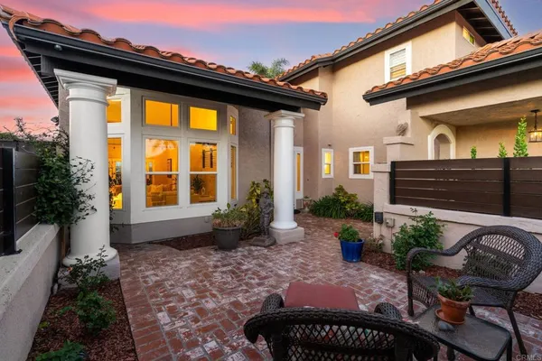 a view of a house with backyard and sitting area
