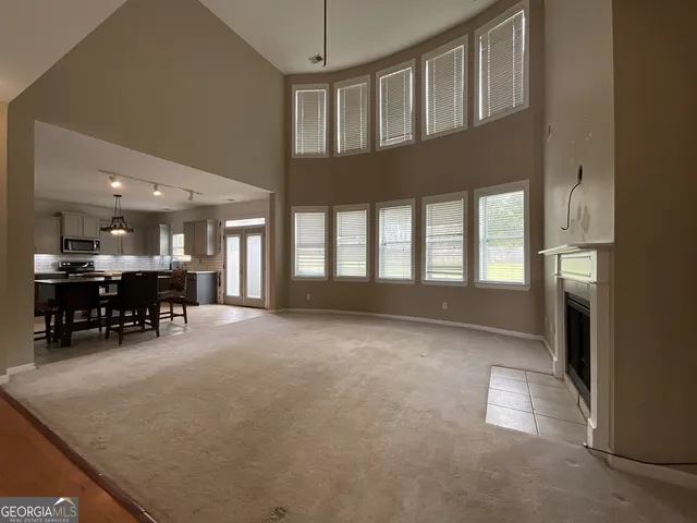 a view of an empty room and kitchen with furniture
