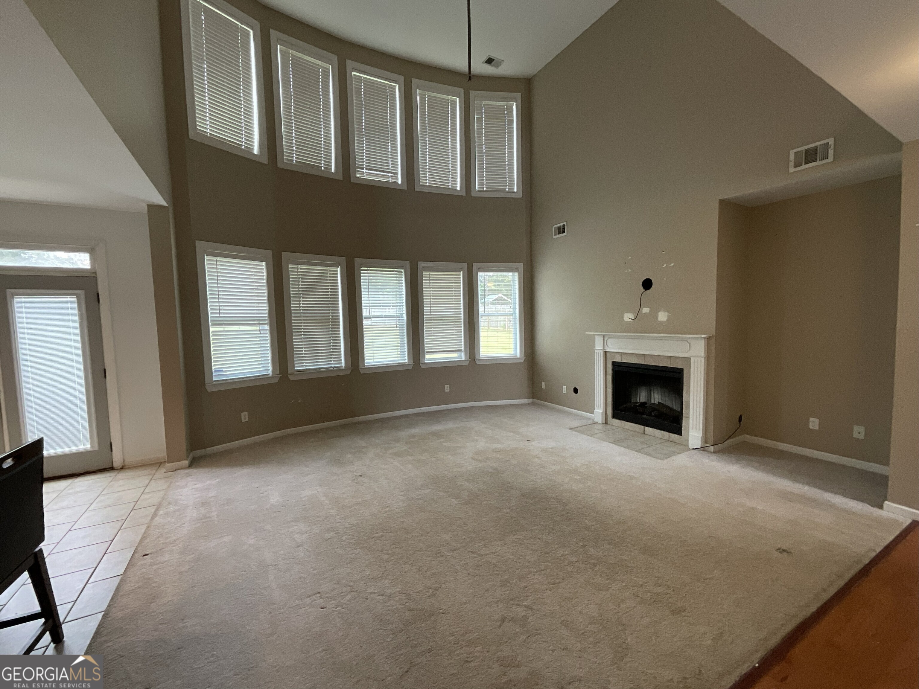302 Brampton Way Perry, GA 31069 - Photo 12 of 39 a view of an empty room with a fireplace and a window