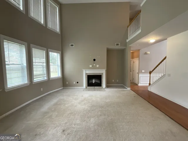a view of an empty room with a fireplace and a window