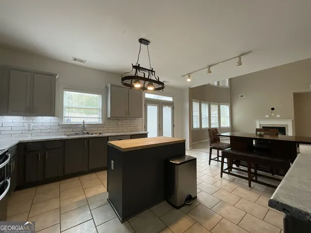 a kitchen with granite countertop cabinets a stove a sink and a counter top space