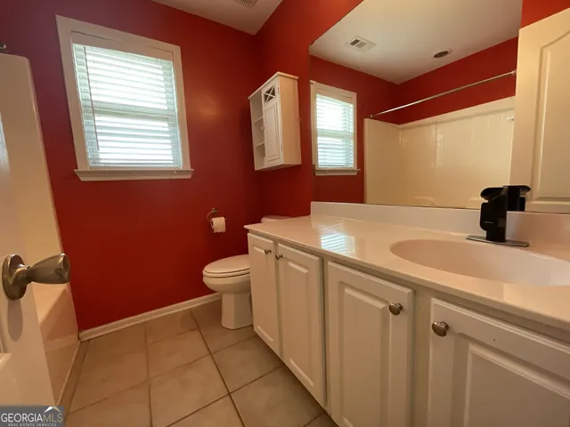a bathroom with a sink a toilet and mirror