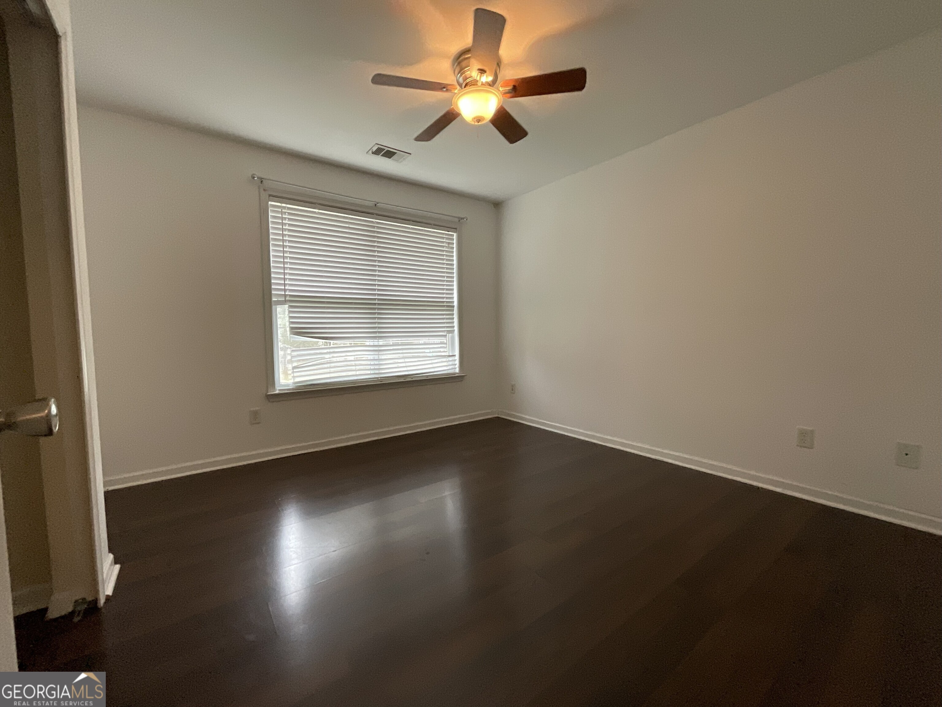 302 Brampton Way Perry, GA 31069 - Photo 29 of 39 an empty room with wooden floor chandelier fan and windows