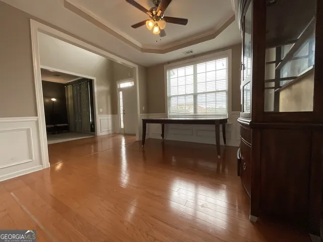 wooden floor in a hall with a window and a livingroom