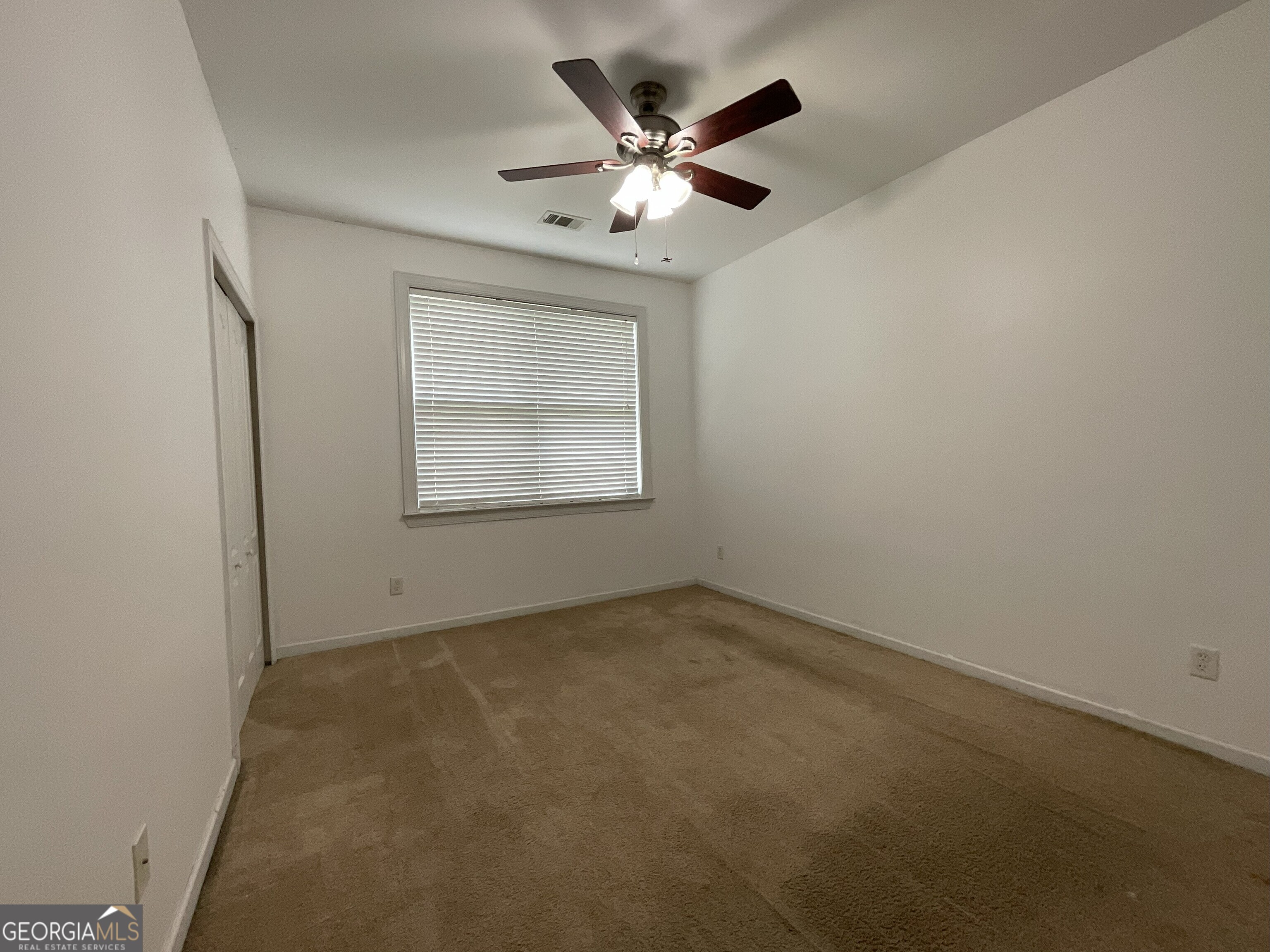 302 Brampton Way Perry, GA 31069 - Photo 8 of 39 an empty room with a ceiling fan and window