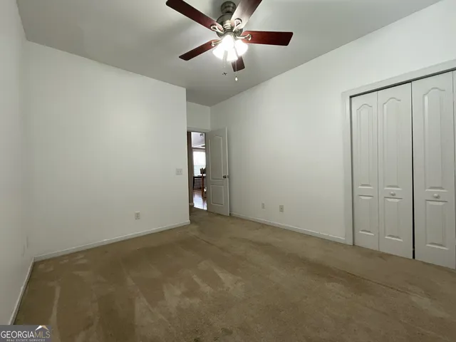an empty room with closet and windows