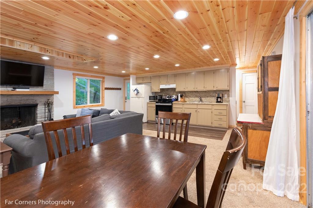 588 Thunderbird Trail Robbinsville, NC 28771 - Photo 16 of 20 a view of a dining room with furniture a fireplace and wooden floor