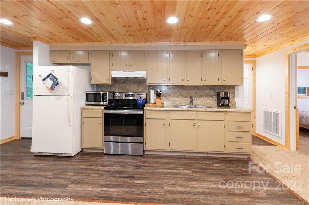 588 Thunderbird Trail Robbinsville, NC 28771 - Photo 9 of 20 a kitchen with a refrigerator a stove top oven a sink and cabinets