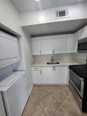 a kitchen with granite countertop white cabinets and white appliances