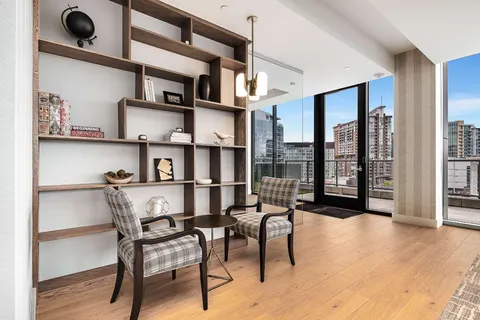 a living room with furniture kitchen view and a flat screen tv