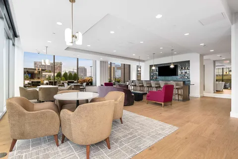 a living room with furniture a flat screen tv and kitchen view