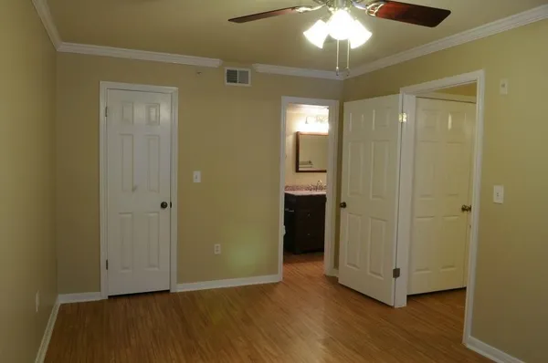 a view of a room with wooden floor mirror and window