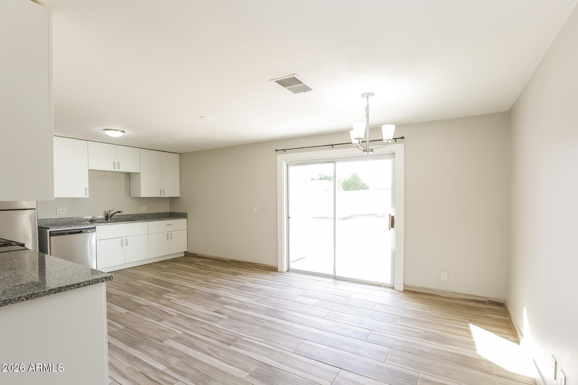 1323 West Romo Jones Street Tempe, AZ 85281 - Photo 5 of 16 a large kitchen with a wooden floor and a large window