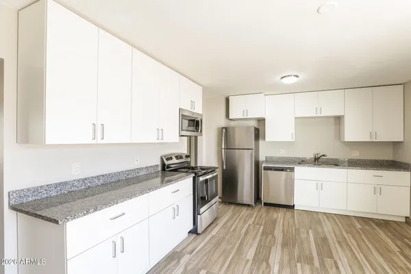 a large kitchen with a wooden floor and a large window