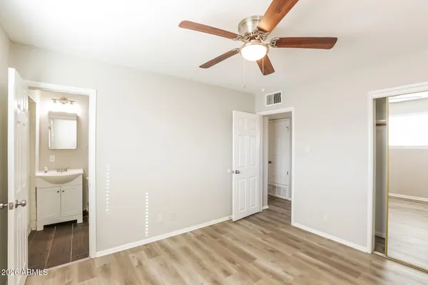 a view of a room with wooden floor and a ceiling fan