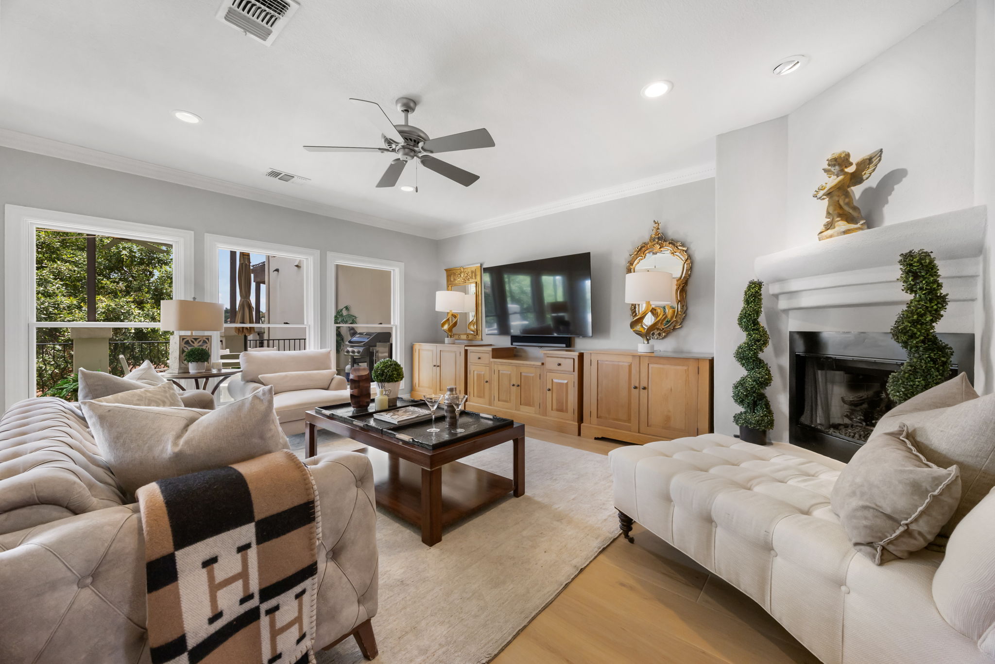 1910 Rue De St Tropez, Unit 6 Austin, TX 78746 - Photo 6 of 37 Hardwood floors and generous windows elevate this spacious living area with a cozy fireplace.
