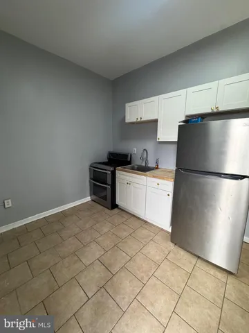 a kitchen with a sink a refrigerator and cabinets