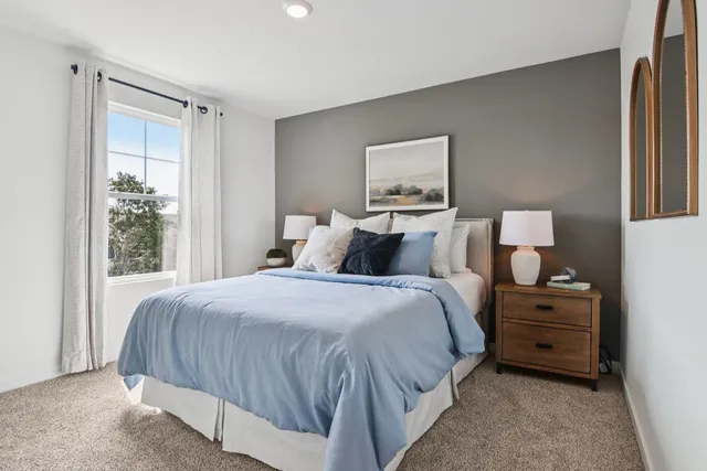 a bedroom with a bed and a painting on the wall