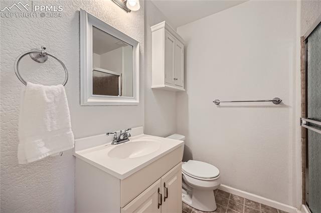 12510 Motley Road Peyton, CO 80831 - Photo 8 of 36 Bathroom with tile flooring, vanity, and toilet