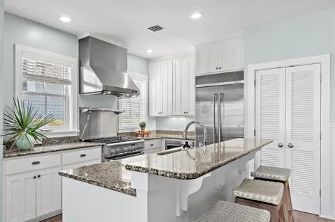 a kitchen with granite countertop a sink and a refrigerator