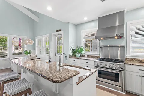 a kitchen with kitchen island granite countertop a stove and a sink