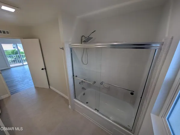a bathroom with a glass door shower