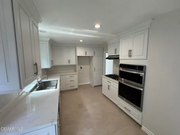 a kitchen with stainless steel appliances granite countertop a sink stove and cabinets
