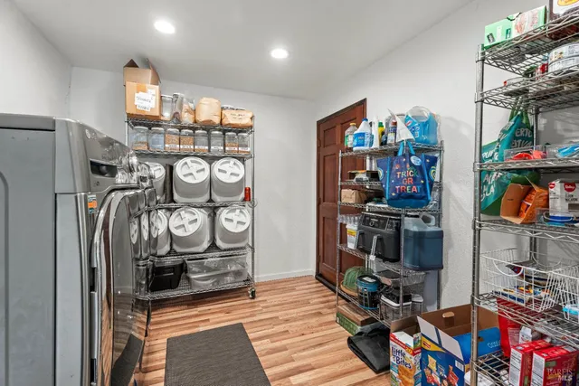 a kitchen with stainless steel appliances granite countertop a refrigerator a sink dishwasher and wooden cabinets with wooden floor