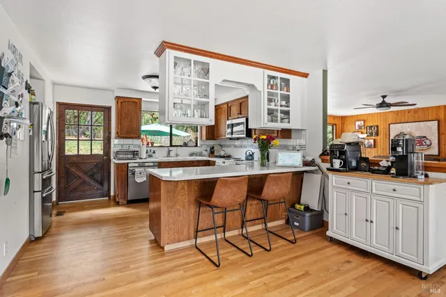 a kitchen with stainless steel appliances granite countertop wooden cabinets a dining table and chairs
