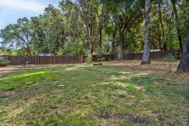 a view of a house with a yard chairs and wooden fence