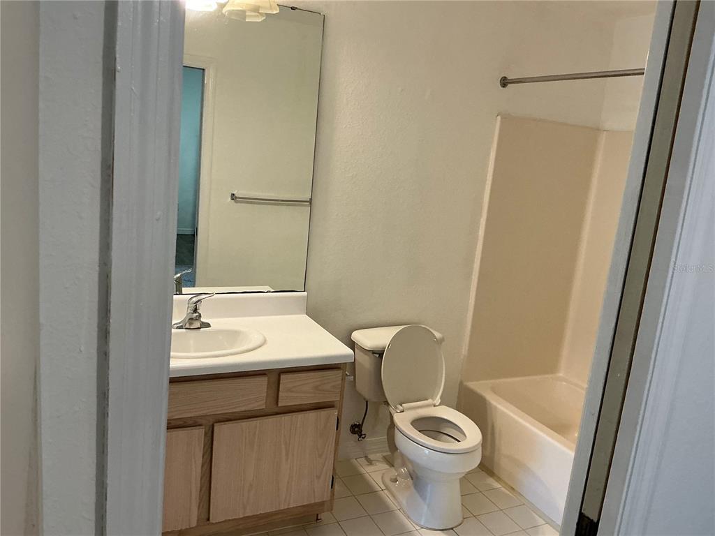 5459 Vineland Road, Unit 4307 Orlando, FL 32811 - Photo 7 of 7 a bathroom with a sink a toilet a mirror and shower