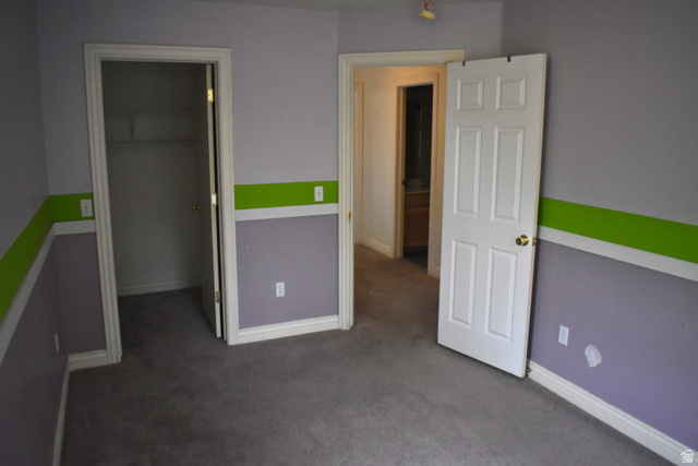 3327 East Windhover Road Eagle Mountain, UT 84005 - Photo 18 of 38 Carpeted room with a closet, white trim, and a six-panel interior door