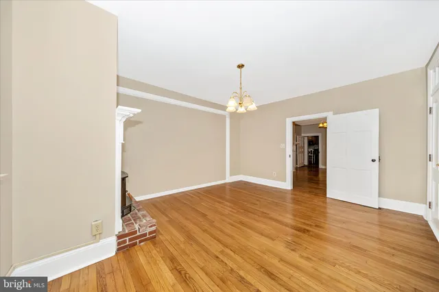 a view of empty room with wooden floor and fireplace