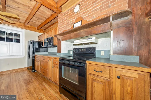 an empty room with a fireplace and chandelier