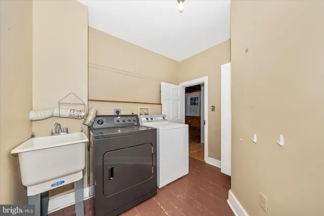 an empty room with wooden floor chandelier fan and windows