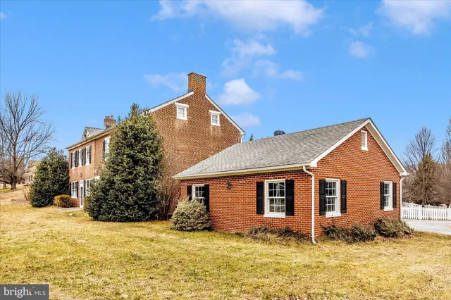 a front view of a house with a yard covered with snow