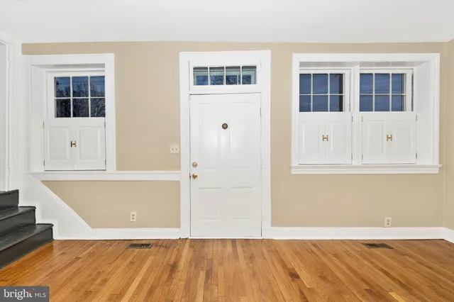 a view of an empty room with wooden floor and closet
