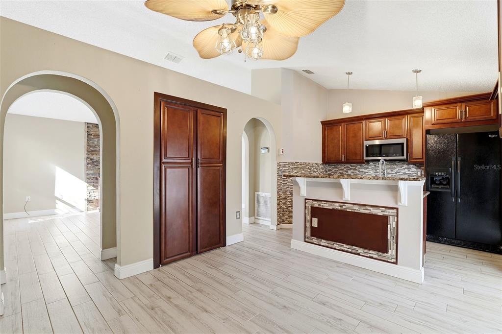 10517 Rocking A Run Orlando, FL 32825 - Photo 13 of 29 a view of a kitchen with a fireplace a ceiling fan and wooden floor