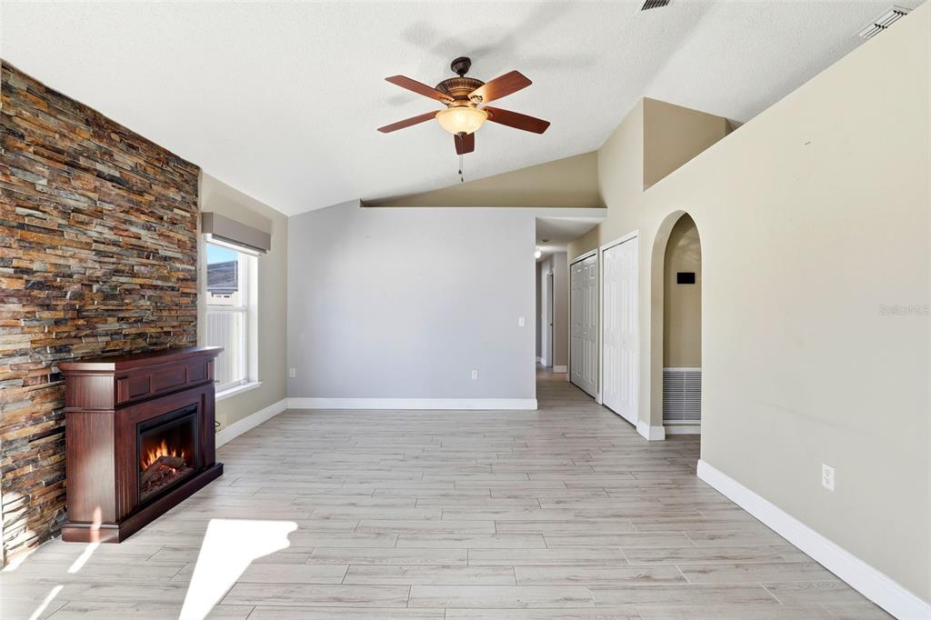10517 Rocking A Run Orlando, FL 32825 - Photo 9 of 29 wooden floor in white room with a fireplace and a ceiling fan