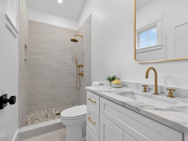 a bathroom with a sink a toilet and shower