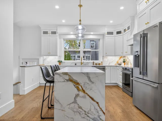 a kitchen with stainless steel appliances granite countertop a refrigerator and a stove