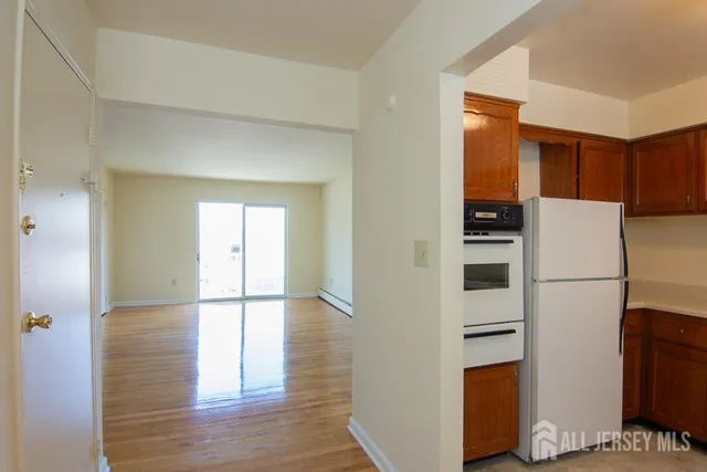 a walk in closet with wooden floor and cabinets