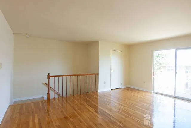 a view of a room with wooden floor and a window