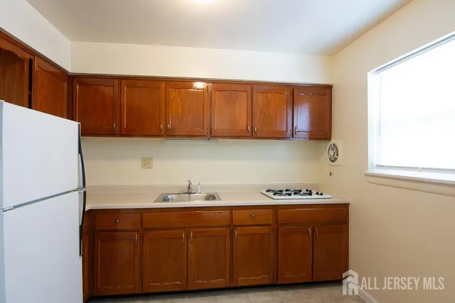 a kitchen with stainless steel appliances granite countertop a sink cabinets and a refrigerator