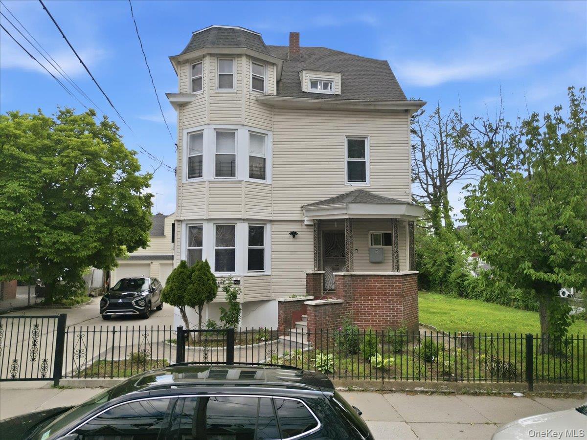 844-48 East 215th Street Bronx, NY 10467 - Photo 1 of 13 a front view of a house with a garden