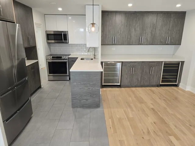 a kitchen with stainless steel appliances a refrigerator and a stove top oven