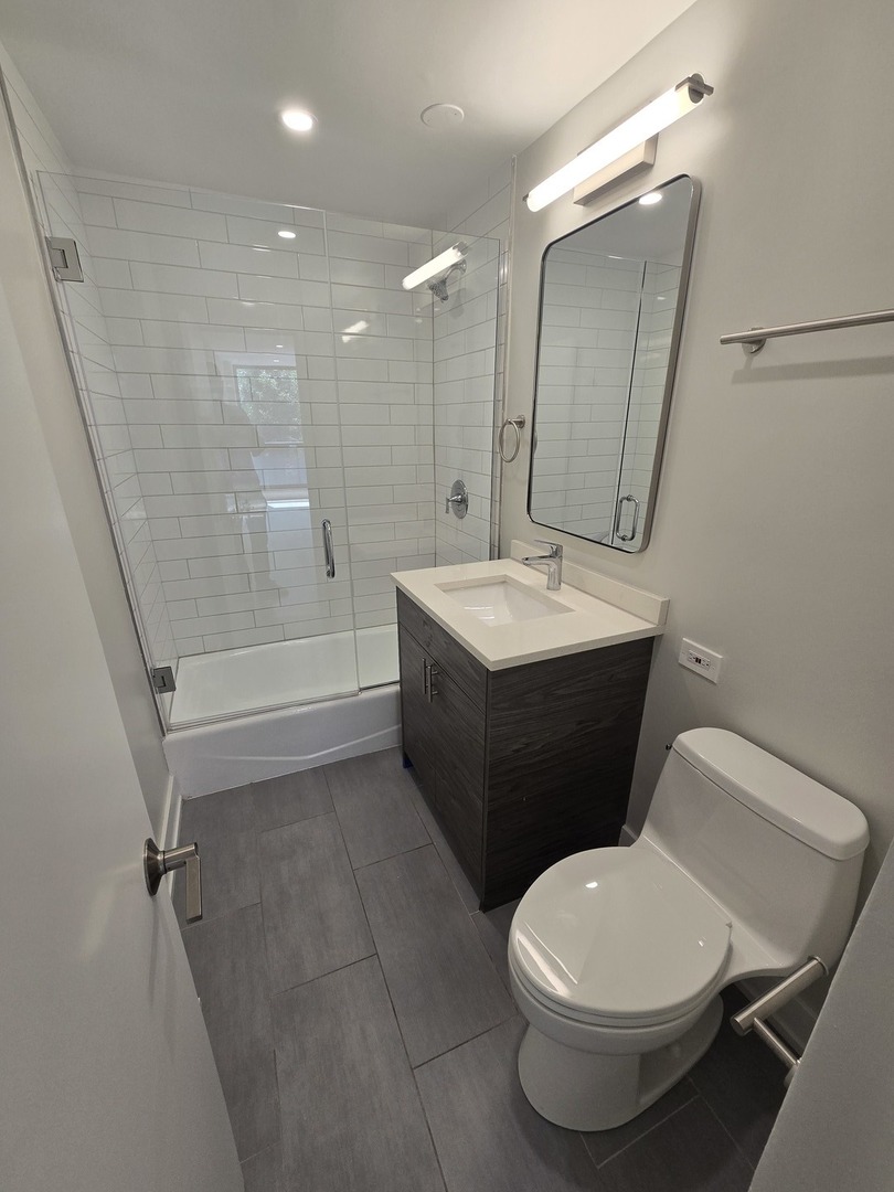 227 East Walton Place, Unit 3W Chicago, IL 60611 - Photo 7 of 15 a bathroom with a toilet sink and mirror